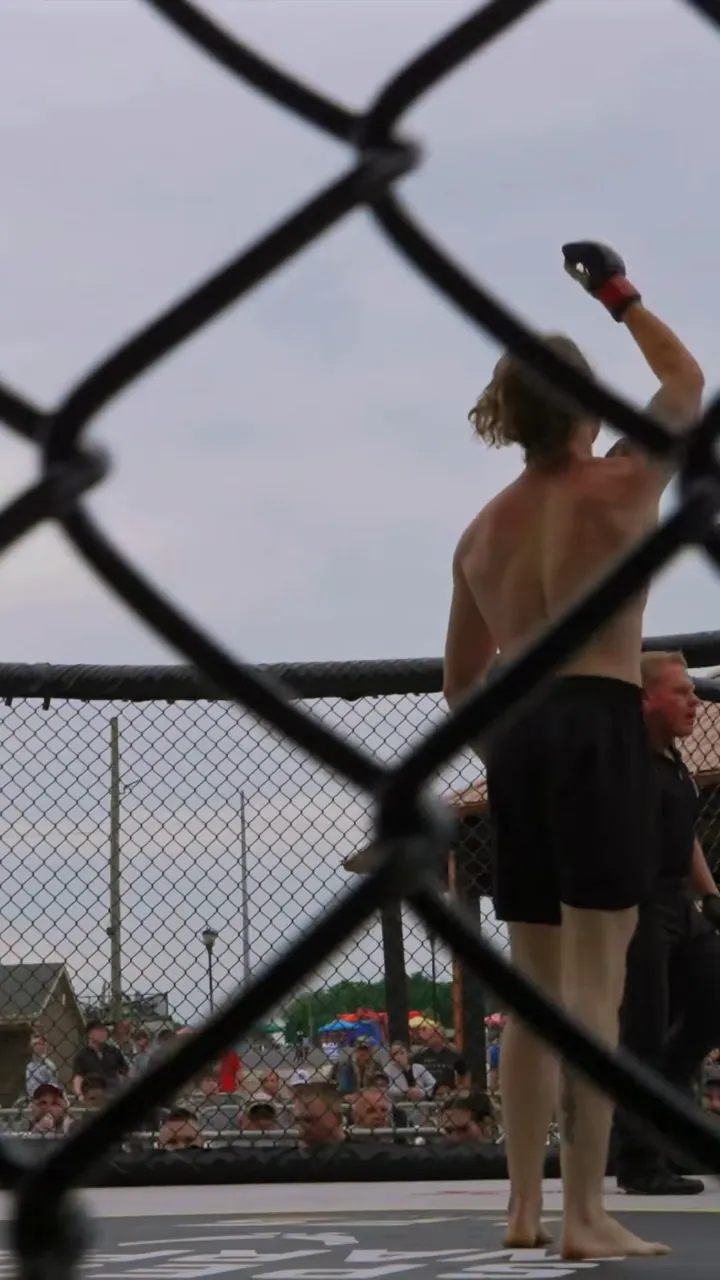 Nathan Johnson raising his fist in the cage after his debut win