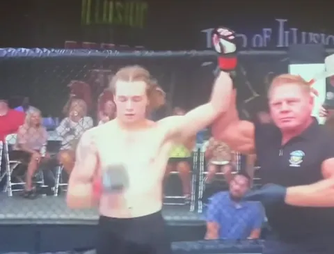 The referee raises Nathan Johnson's hand after his debut win (broadcast, filmed off a TV)