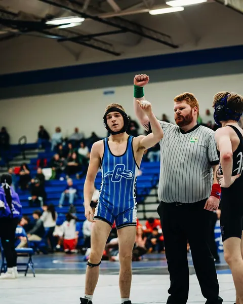 High-school Nathan Johnson with his hand raised after a wrestling win